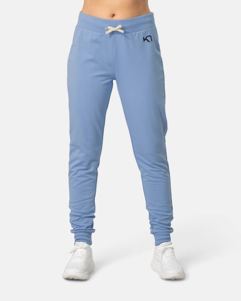 Woman modeling the light blue Kari Traa Kari Pant, showing its slim-fit style and ribbed ankle cuffs for lounging.