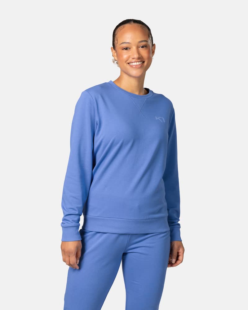 Woman wearing the Kari Traa Kari Crew sweater in sea blue, showcasing its comfortable fit for everyday style.