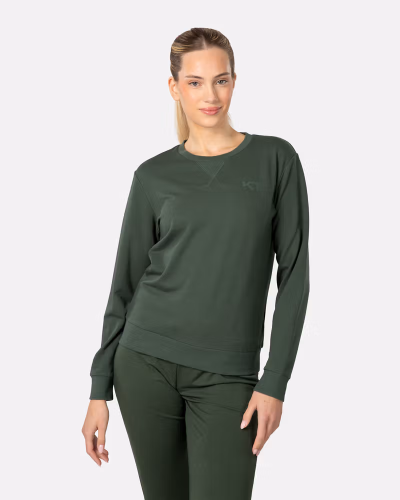 Woman wearing the Kari Traa Kari Crew sweater in dark green, showcasing its relaxed fit for everyday comfort.