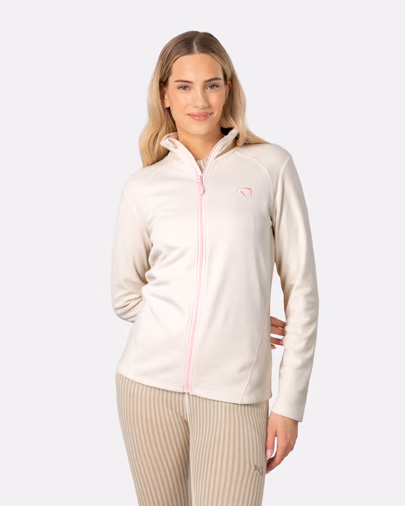 Woman wearing the cream Kari Traa Kari Full Zip Fleece, showing its cozy high collar and soft feel.
