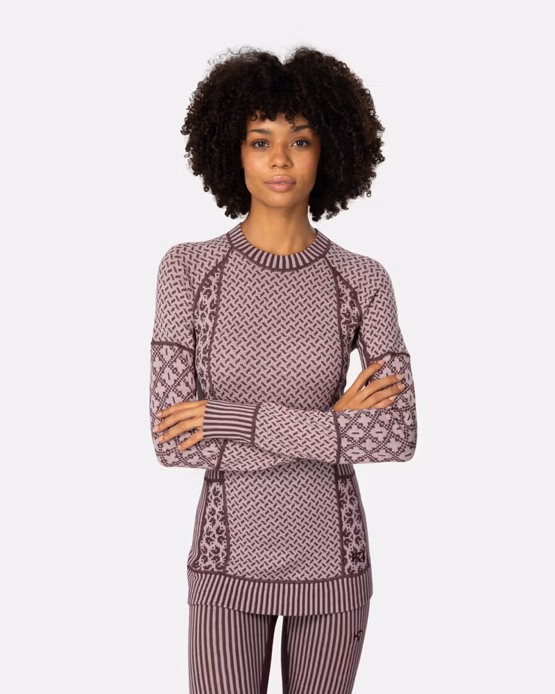 Woman wearing the dusty rose Kari Traa Smekker Long Sleeve, showing how the mixed knit patterns create a flattering, slim fit.