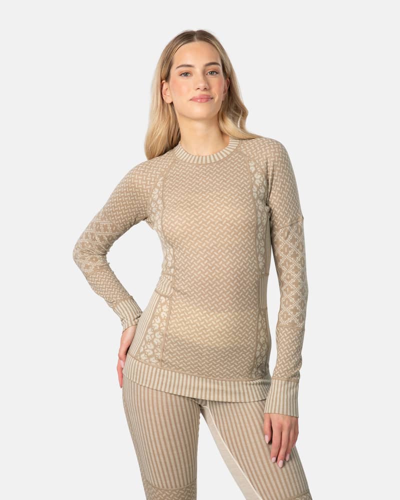 Woman wearing the complete beige Kari Traa Smekker baselayer set, showcasing the top's flattering slim fit and soft feel.