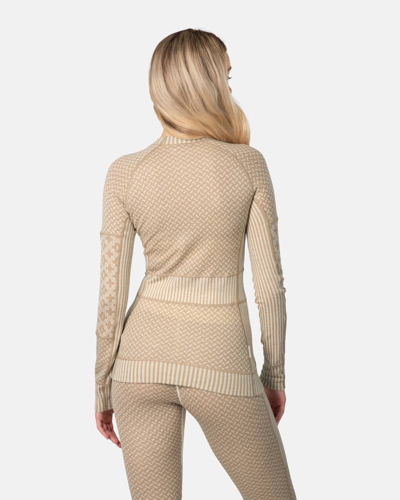 Back view of a woman wearing the beige Kari Traa Smekker Long Sleeve, highlighting how the different knit panels create a flattering shape.