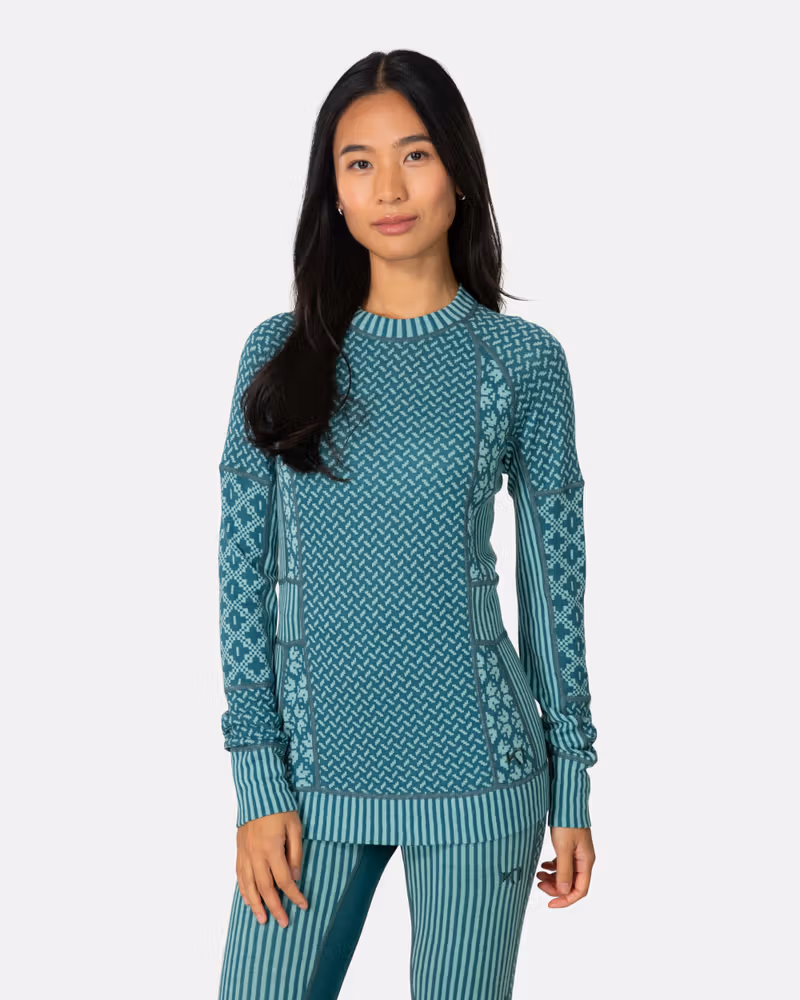 Woman wearing the teal Kari Traa Smekker Long Sleeve, showing the jacquard-knit panels and slim fit.