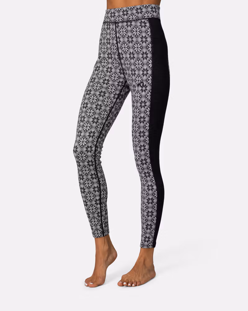 Side view of a woman in black Kari Traa Rose High Waisted Baselayer Pants, showing the flattering silhouette.