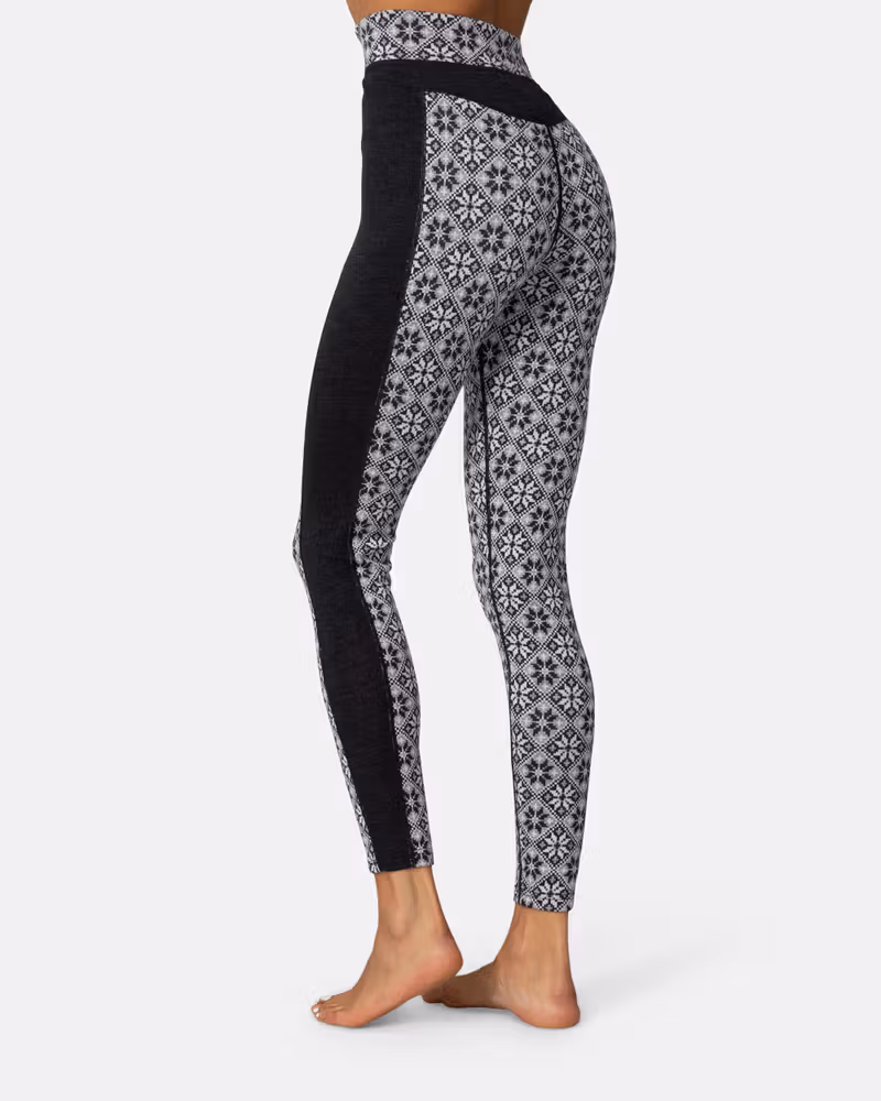 Back view of a woman wearing black Kari Traa Rose High Waisted Baselayer Pants, detailing the fit and pattern.