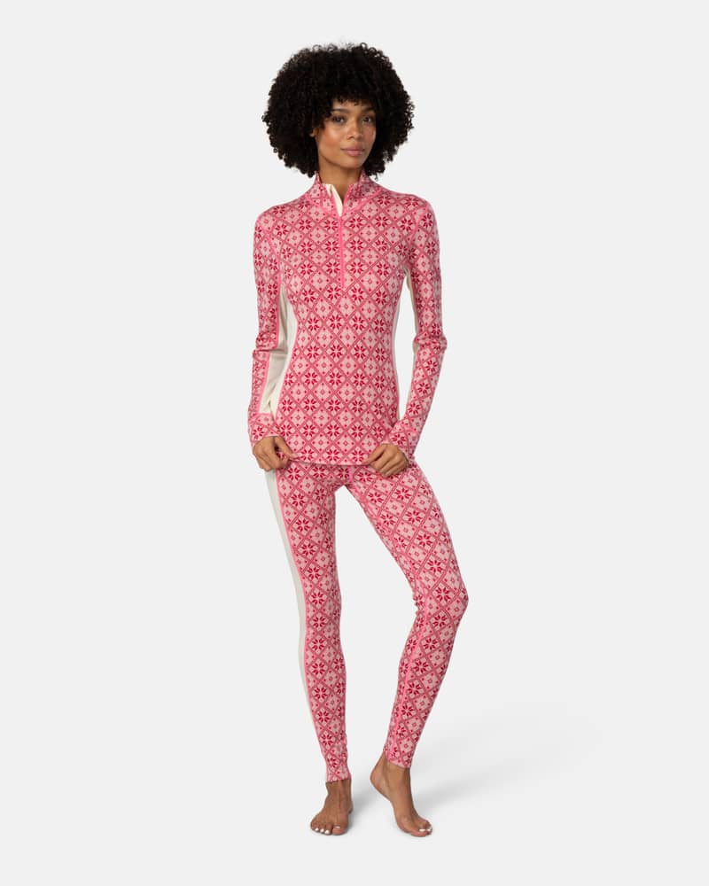 Woman wearing red patterned Kari Traa Rose High Waisted Baselayer Pants with a matching top for a complete look.