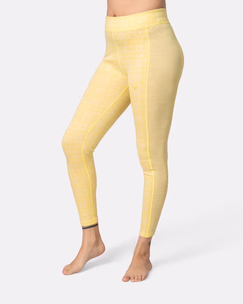 Side view of the yellow Kari Traa Rose High Waist Pants, showing the slim fit and breathable side panels.