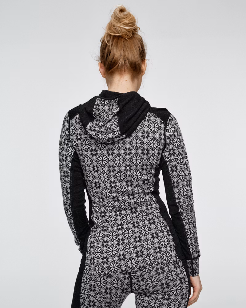 Back view of a woman in the black Kari Traa Rose Base Layer Hoodie, showing the slim fit and hood detail.