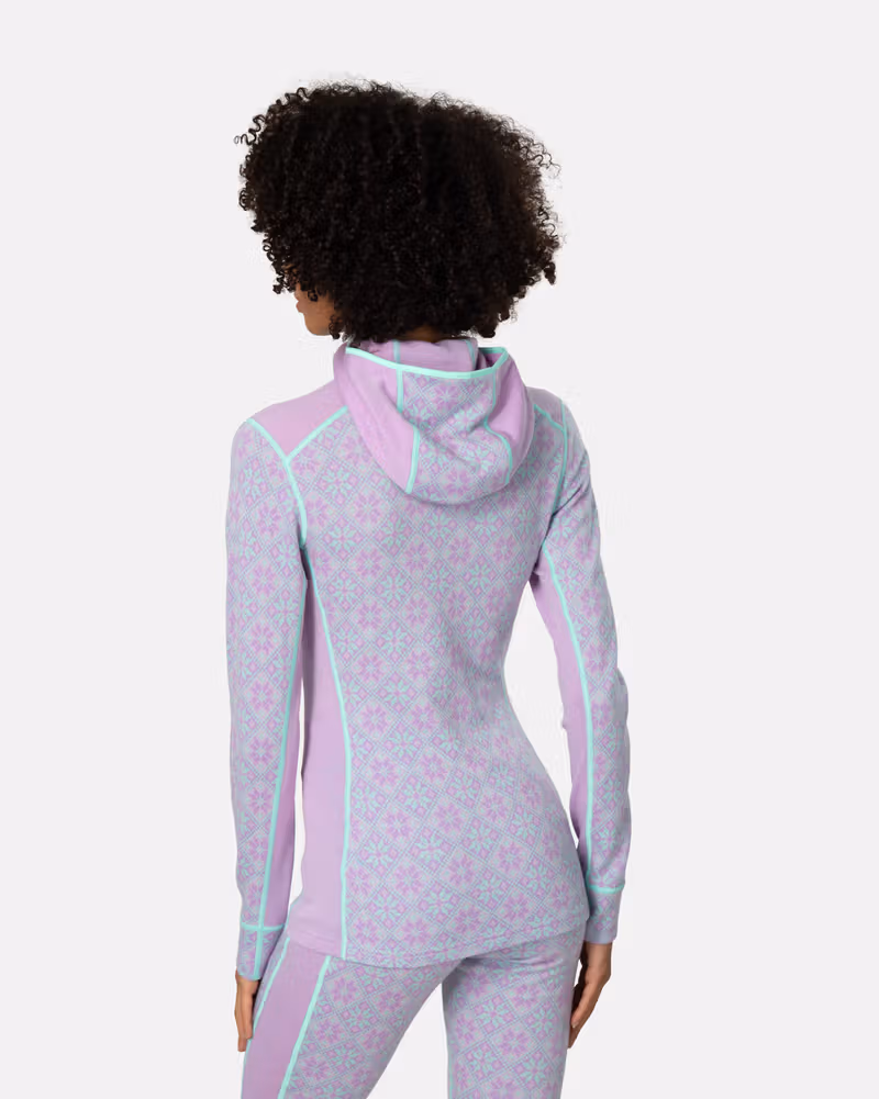 Back view of a woman wearing the lavender Kari Traa Rose Base Layer Hoodie, highlighting the contrast side details.