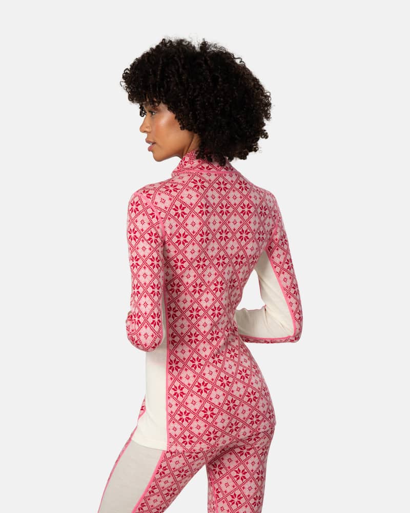 Back view of a woman in the pink patterned Kari Traa Rose Half Zip top, highlighting the flattering lines.