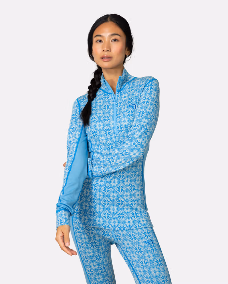 Woman wearing the light blue Kari Traa Rose Half Zip top and matching pants for a coordinated baselayer look.