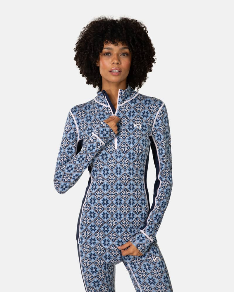 Woman wearing the navy floral Kari Traa Rose Half Zip Base Layer Top, showing the zip collar and Nordic pattern.