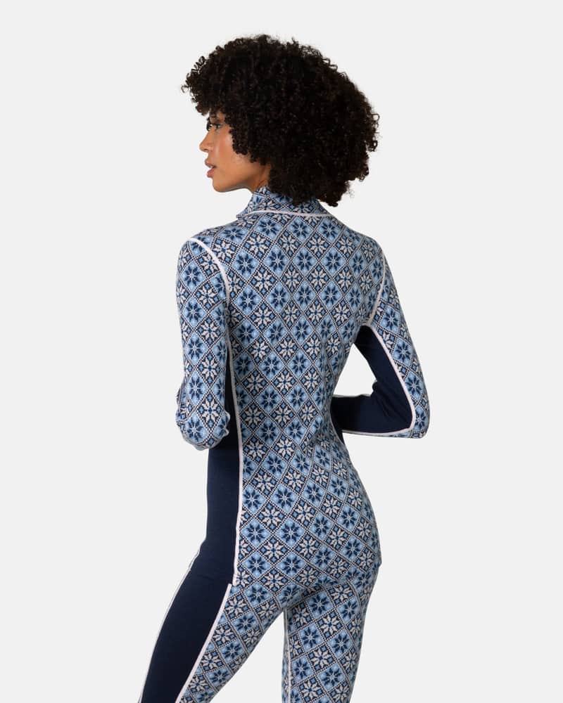Back view of a woman in the navy floral Kari Traa Rose Half Zip top, highlighting the slim, athletic fit.