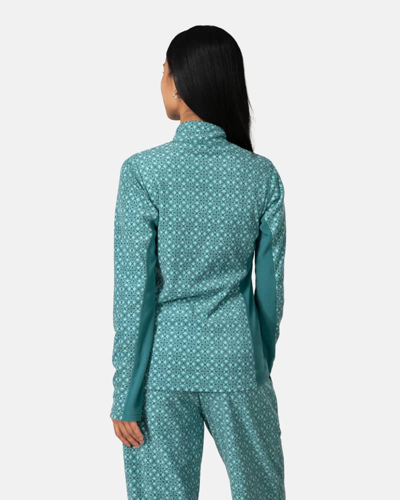 Back view of a woman in the teal Kari Traa Olga Fleece, showcasing the relaxed silhouette and embroidered logo.