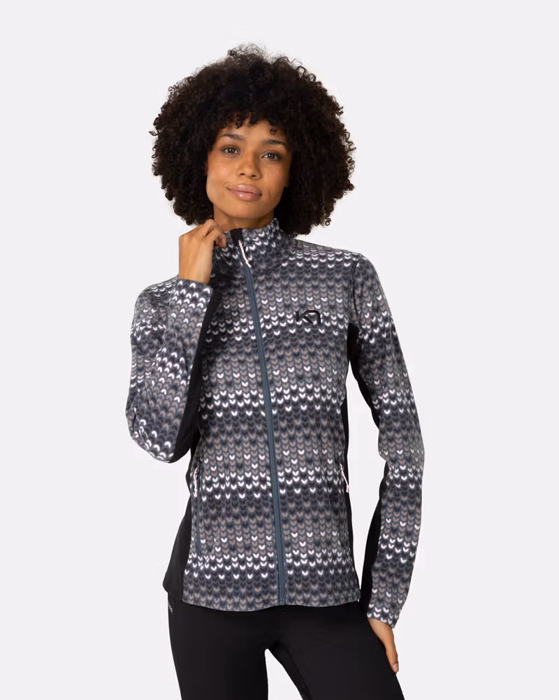 Woman wearing the grey patterned Kari Traa Olga Fleece, showing the relaxed silhouette and secure zippered hand pockets.