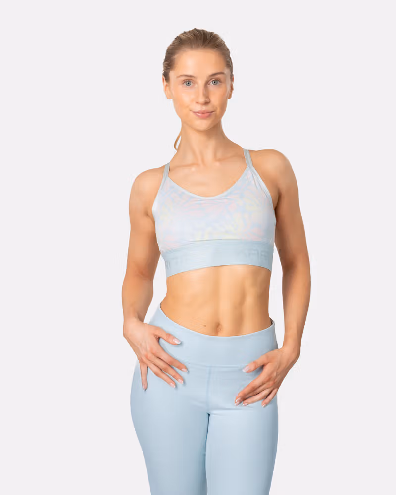 Woman wearing the Kari Traa Frøya Sports Bra in a light blue print, a wool-lined bra for light-impact adventures.