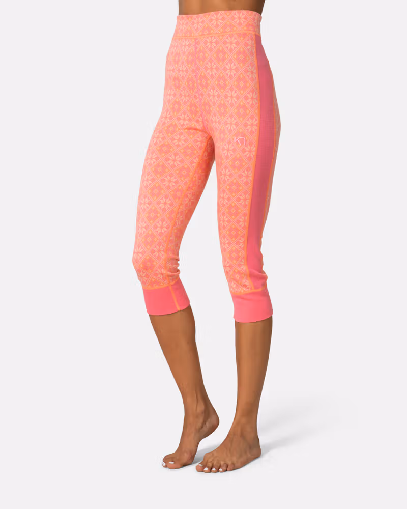 Side view of a woman wearing pink Kari Traa Rose High Waist Capri, showing the below-the-knee length.