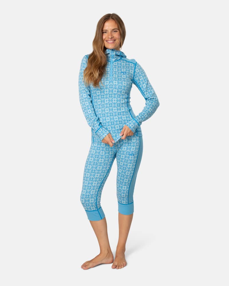 Woman wearing the complete light blue Kari Traa Rose baselayer set with the high waist capri and matching hoodie.