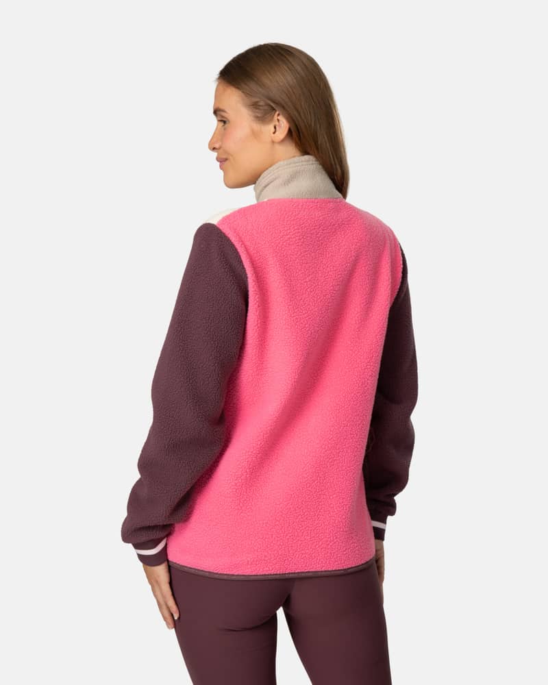 Back view of a woman wearing the color-blocked pink and maroon Kari Traa Røthe Midlayer fleece.