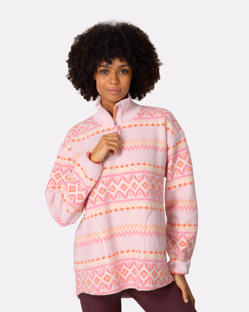 Woman wearing the pink striped Kari Traa Ruthie Midlayer, showing its cozy high collar and soft texture.