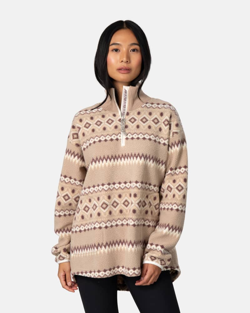 Woman wearing the beige striped Kari Traa Ruthie Midlayer, perfect for a cozy, stylish look.