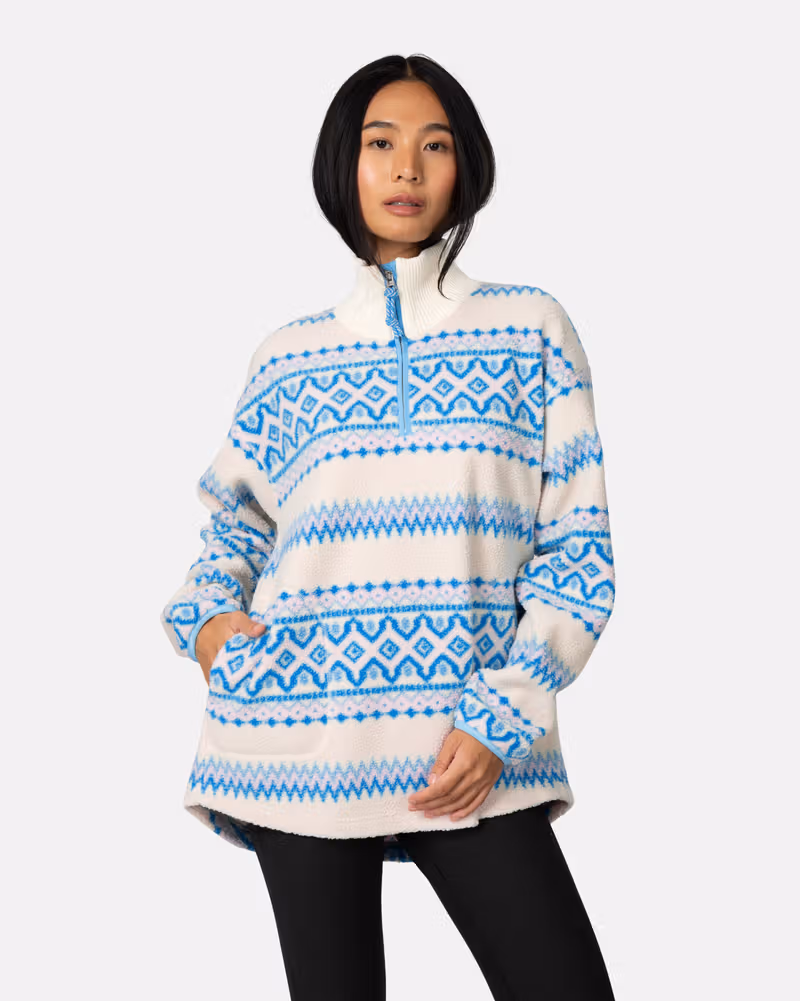 Woman wearing the blue striped Kari Traa Ruthie Midlayer, showcasing its relaxed fit and soft feel.
