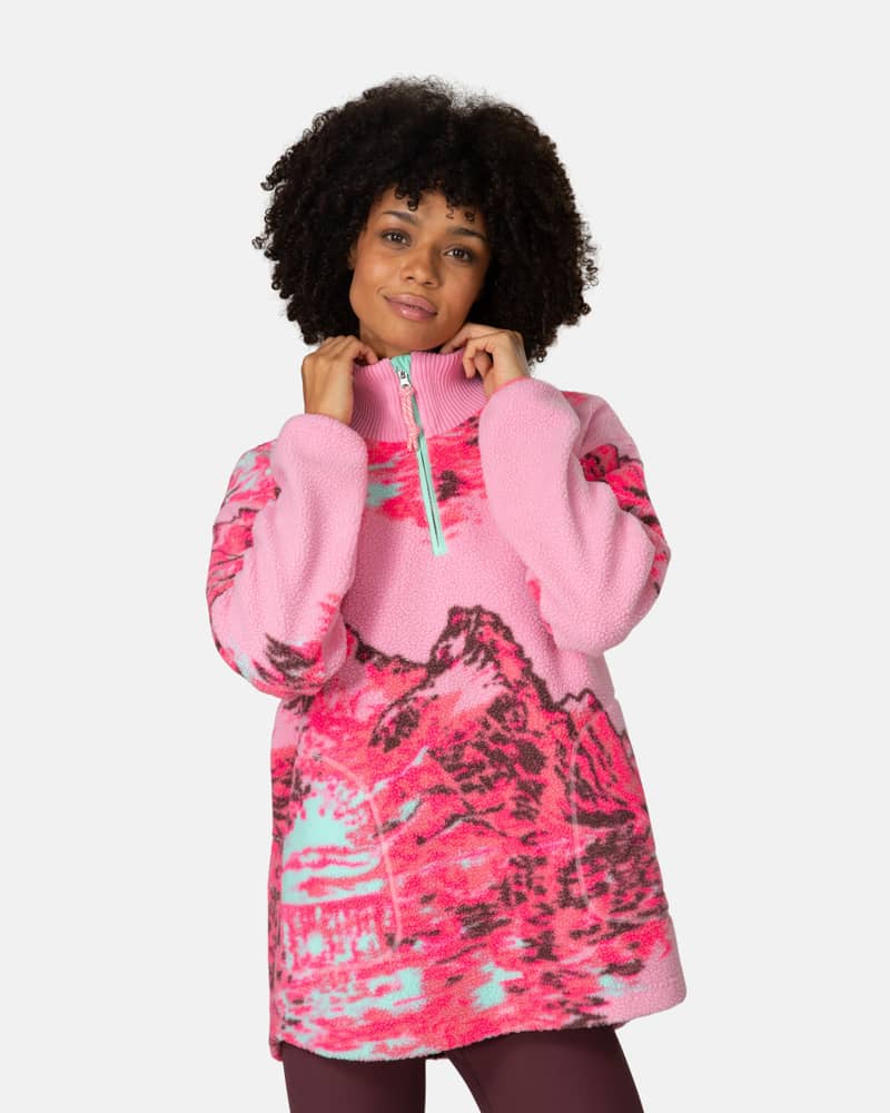 Woman wearing the pink Kari Traa Ruthie Midlayer with a mountain graphic, showing the loose, relaxed fit.