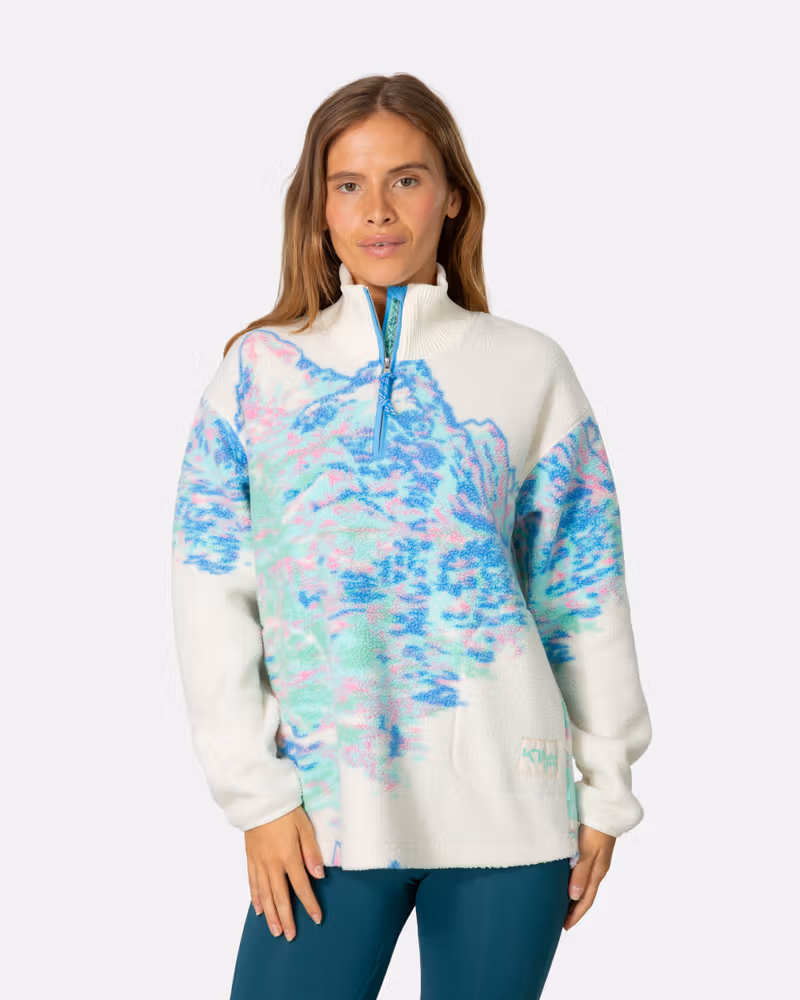 Woman wearing the Kari Traa Ruthie Midlayer with a blue wave graphic, showcasing its unique and stylish pattern.