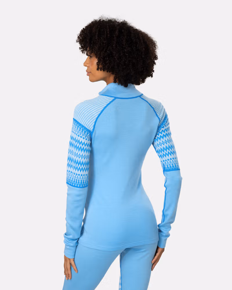Back view of a woman in the light blue Kari Traa Silja 2.0 Half Zip, highlighting the slim fit and arm pattern.