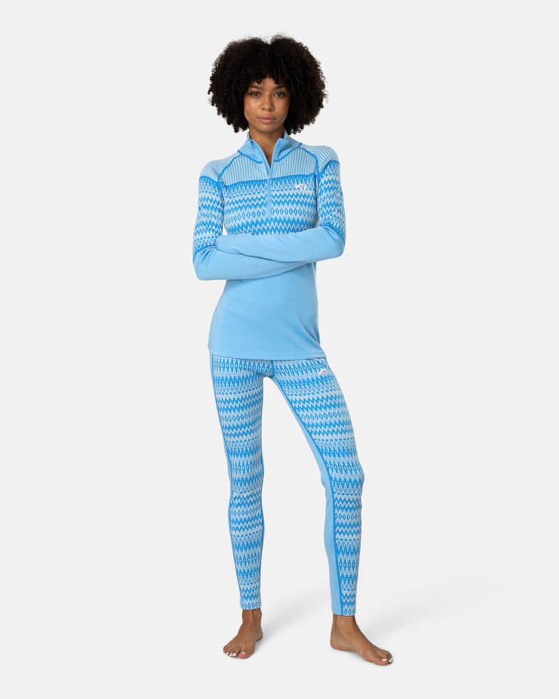 Woman styled in the complete light blue Kari Traa Silja 2.0 set, featuring the half-zip top and matching leggings.