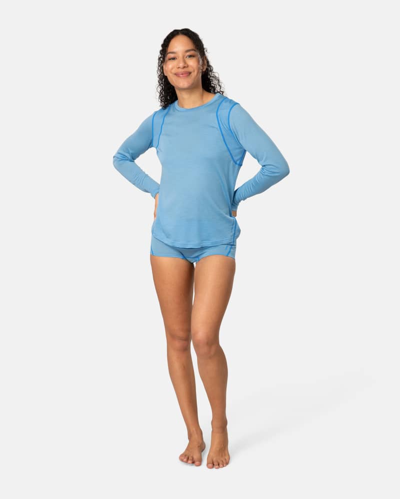 Woman wearing the blue Kari Traa Embla Wool Boxer with a matching long-sleeve top, a soft Merino wool underwear set.