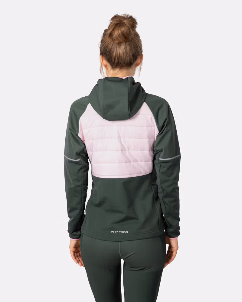 Back view of a woman wearing the green Kari Traa Nia Jacket, highlighting the pink quilted panel for warmth during runs.