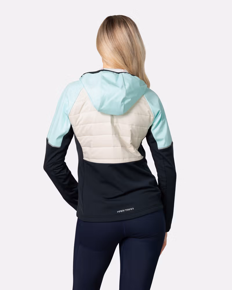 Back view of a woman in the Kari Traa Nia running jacket, showing the quilted back panel and reflective details for visibility.