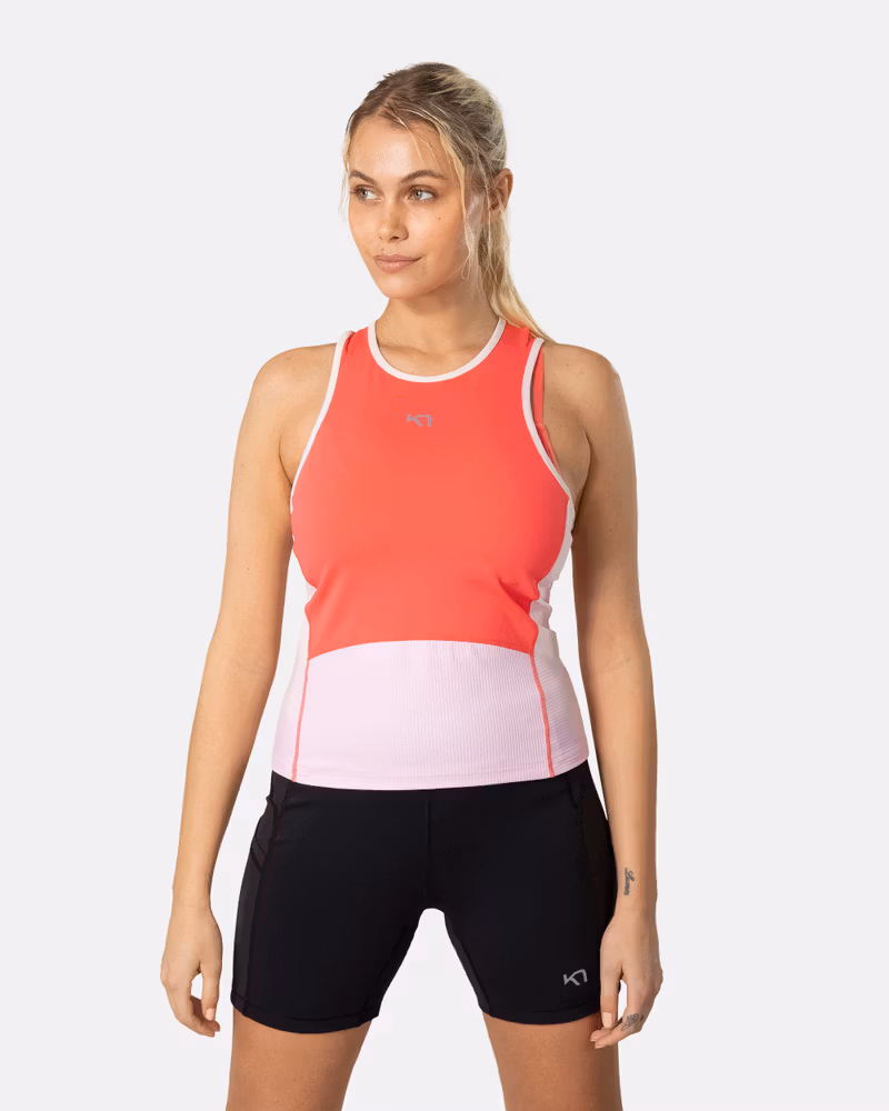 Woman wearing the Kari Traa Linnea Top in candy, a vibrant pink performance tank perfect for the gym or trail runs.