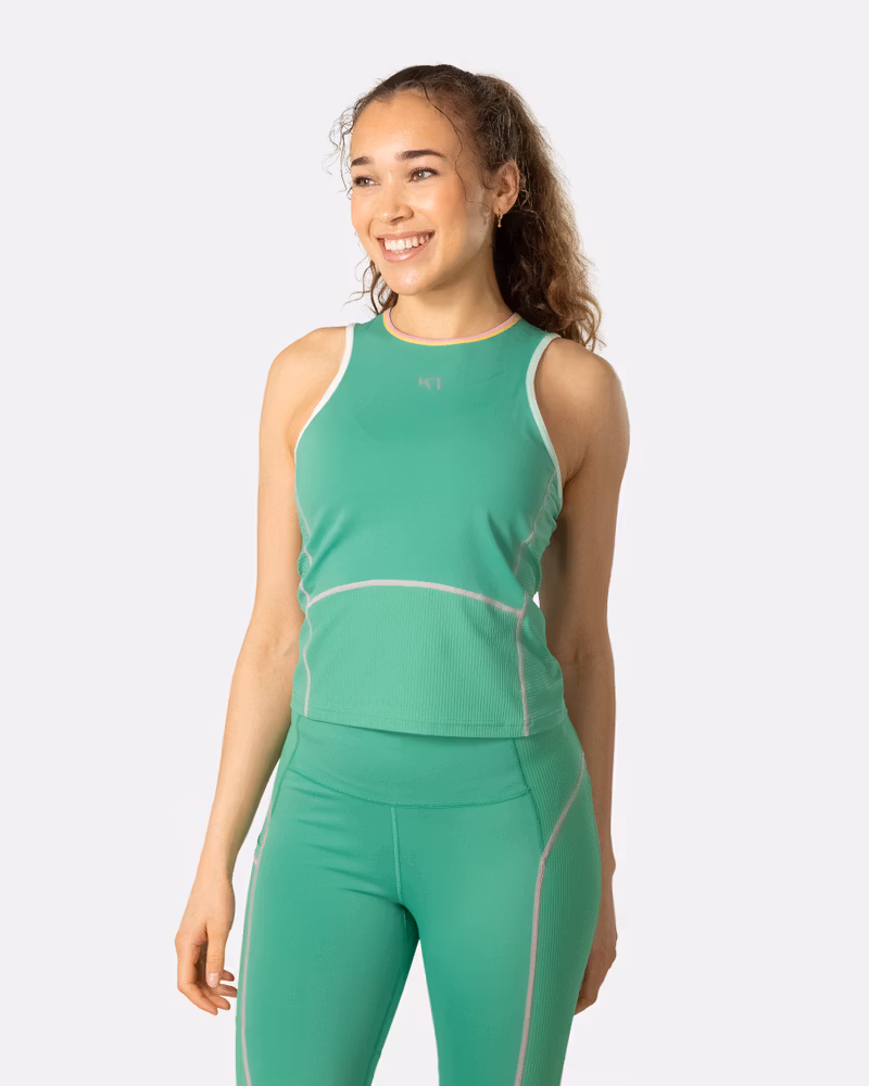 Woman wearing the Kari Traa Linnea Top in green, a breathable performance tank for the gym or trail runs.