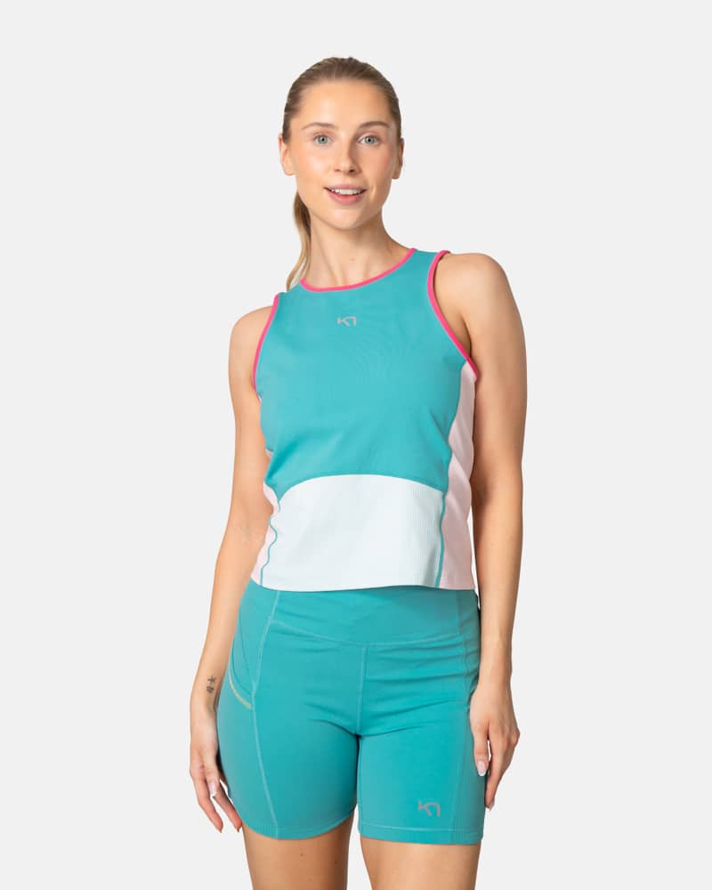 Woman wearing the Kari Traa Linnea Top in turquoise, a breathable performance tank for the gym or trail runs.