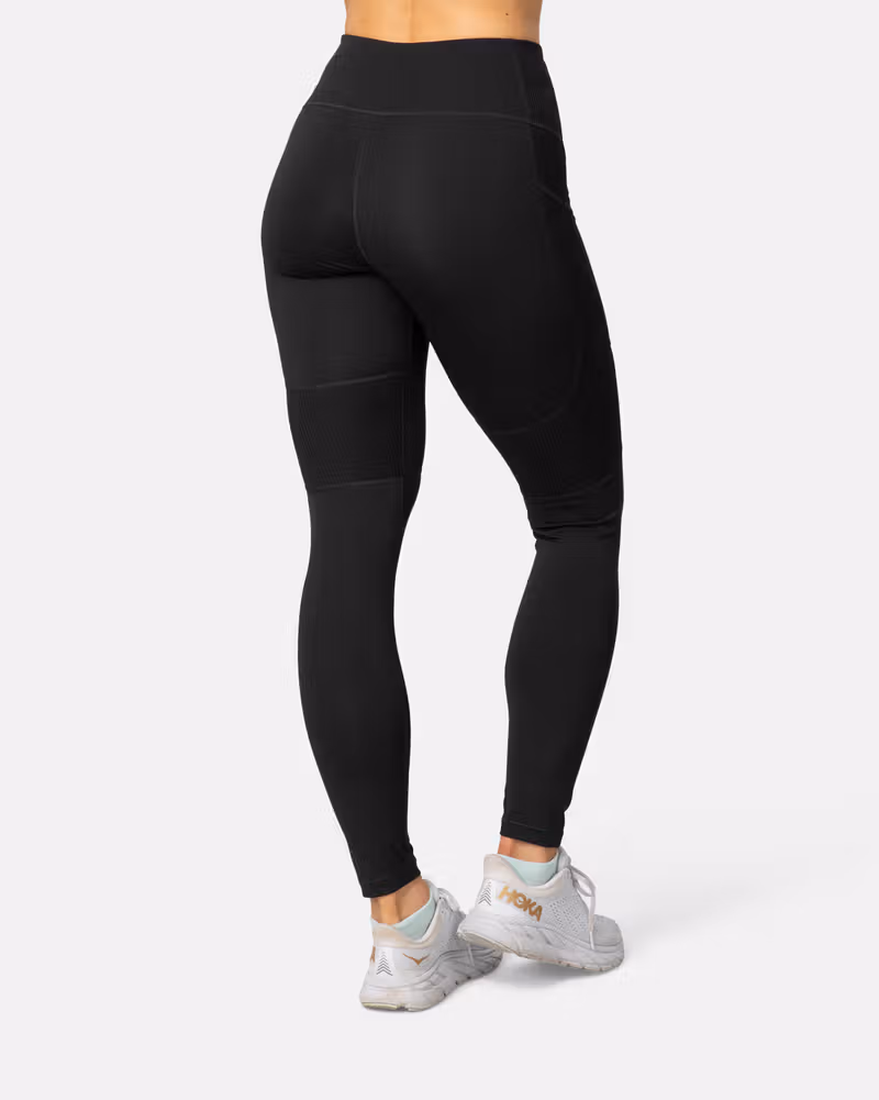 Back view of a woman in the black Kari Traa Linnea Tights, showing the supportive wide waistband and slim fit.