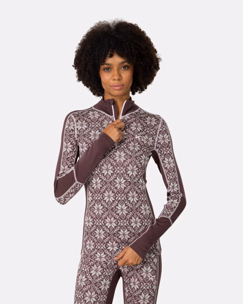 Woman wearing Kari Traa Anna Half Zip in dark red with Nordic snowflake print, merino wool base layer