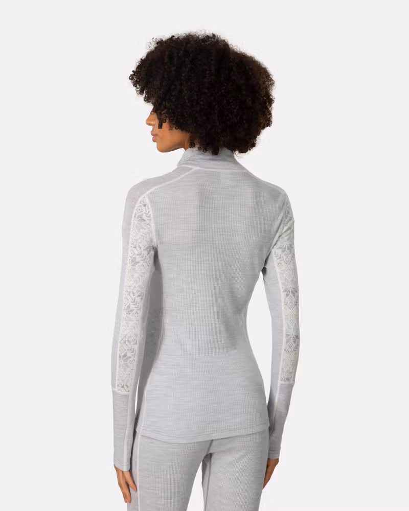 Back view of woman in Kari Traa Anna Half Zip grey melange merino wool base layer, Nordic print sleeves