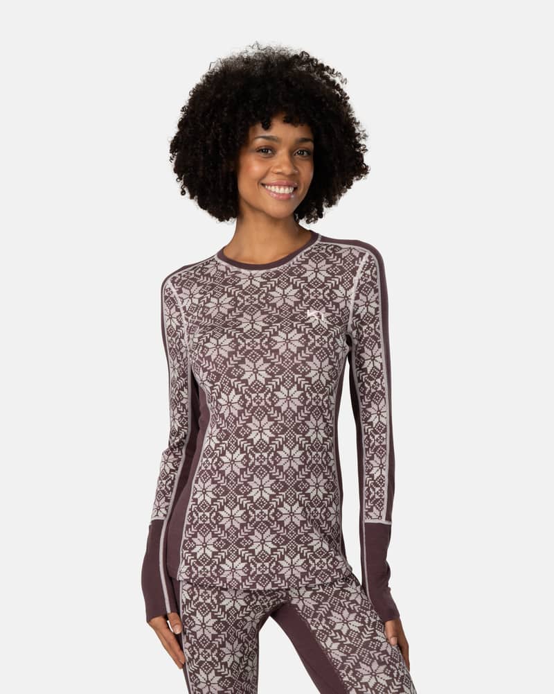 Woman wearing the dusty rose Kari Traa Anna Long Sleeve with a Nordic print, ideal for cold-weather activities.