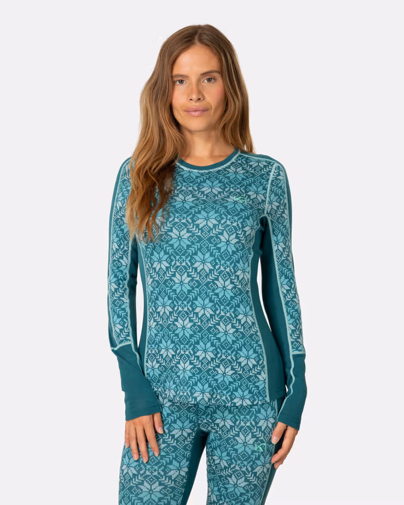 Woman wearing the teal Kari Traa Anna Long Sleeve with a bold Nordic print, showing the slim, flattering fit.