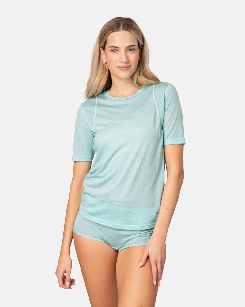 Woman wearing the Kari Traa Embla Wool Tee in turquoise, a breathable base layer for summer workouts and activities.