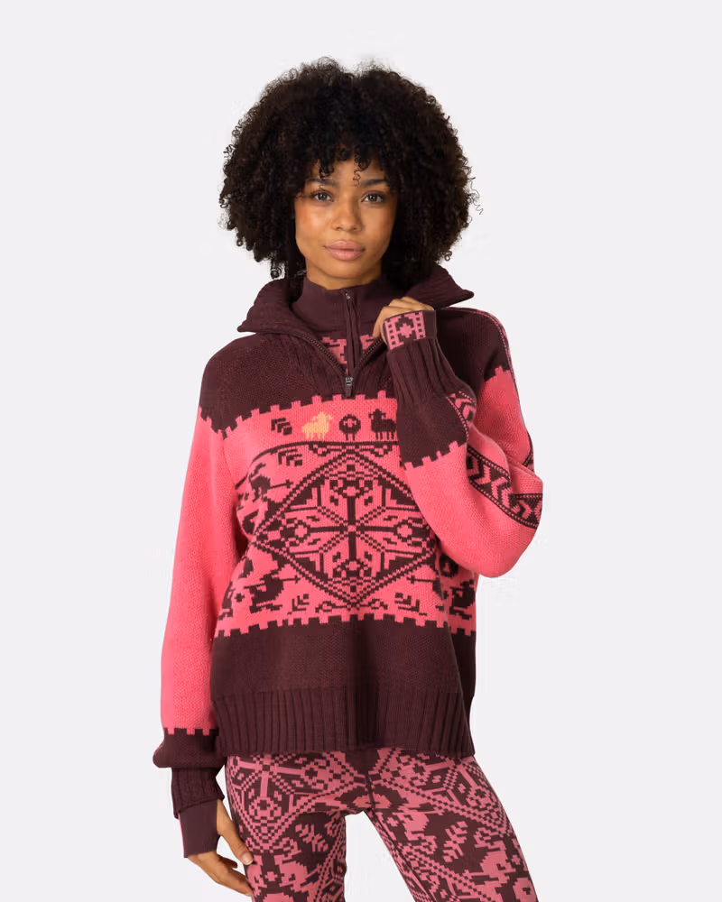 Woman wearing the pink and maroon Kari Traa Saga Knit sweater, a perfect statement piece for the ski lodge or city.