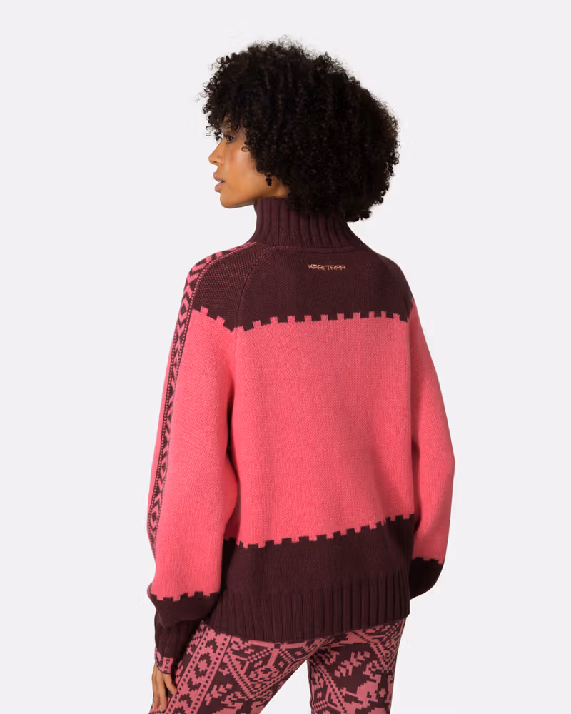 Back view of a woman in the pink and maroon Kari Traa Saga Knit sweater, showing the bold Nordic design.