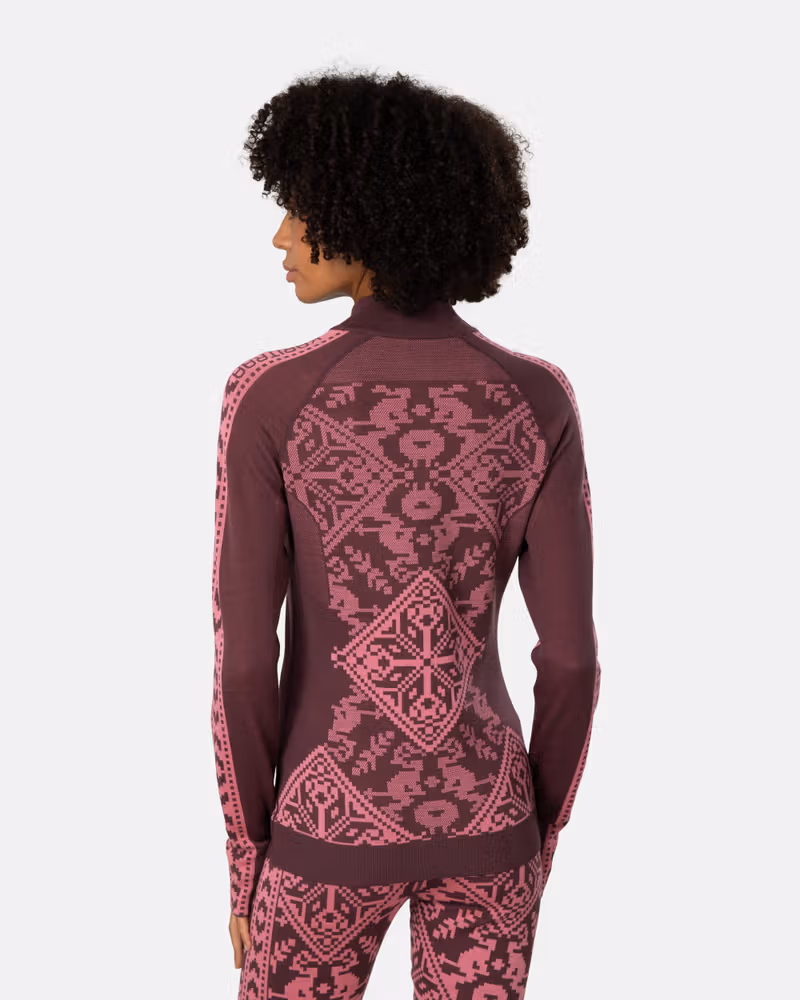 Back view of a woman in the maroon Kari Traa Saga Half Zip, highlighting the strategic mesh ventilation.