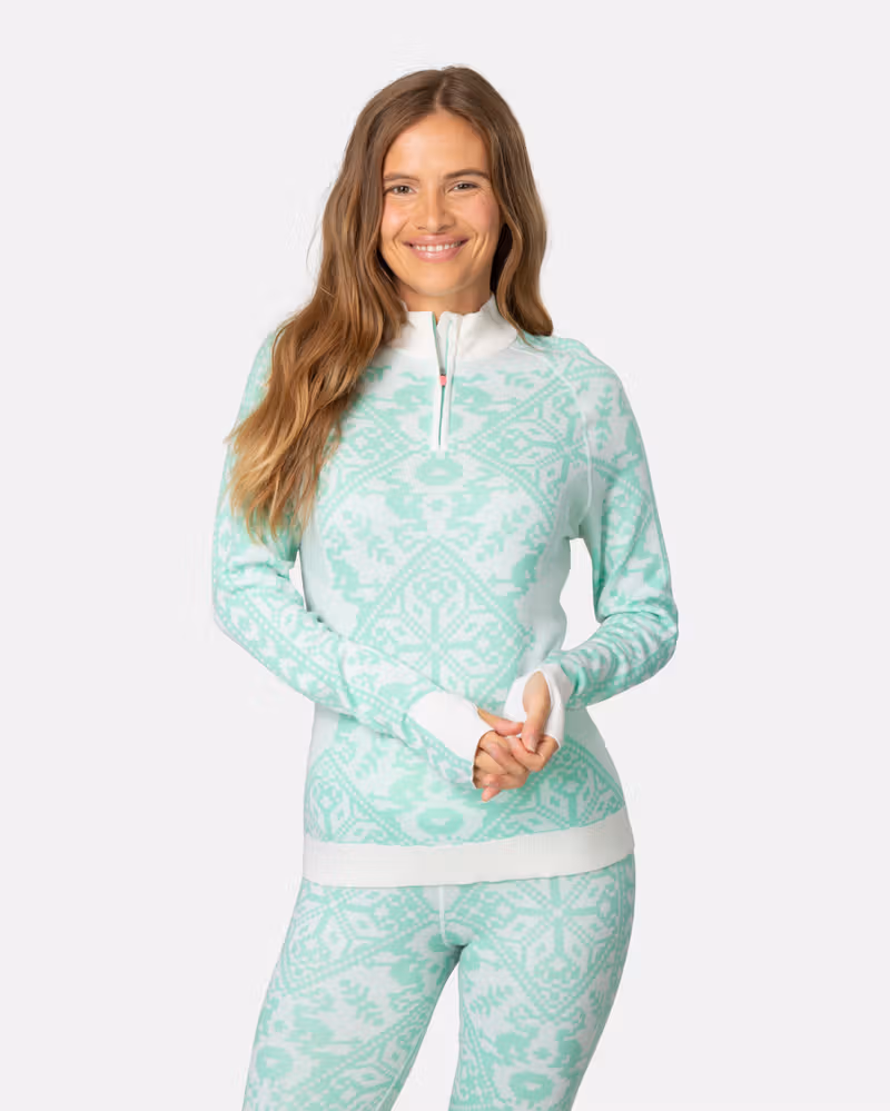 Woman wearing the mint green Kari Traa Saga Half Zip with a Nordic pattern, perfect for layering on the slopes