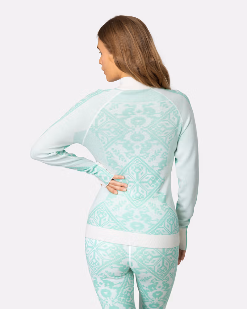 Back view of a woman in the mint green Kari Traa Saga Half Zip, showing the slim fit and raglan sleeves.