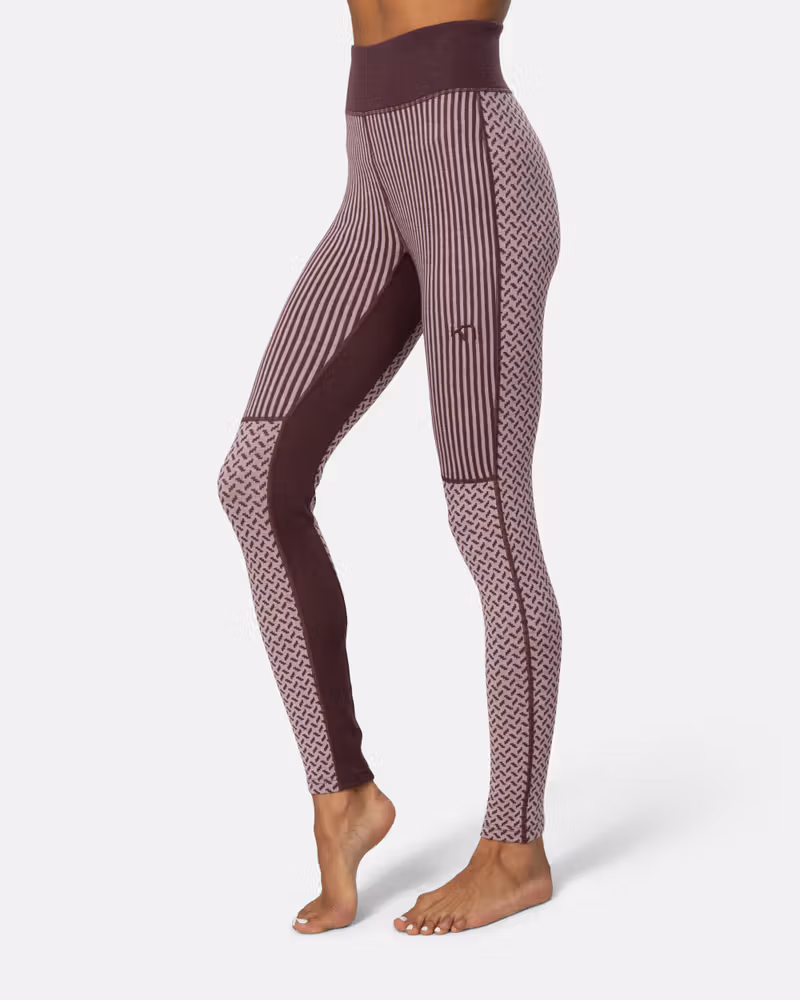 Side view of a woman in dusty rose Kari Traa Smekker High Waist Pants, showing the detailed side panels.