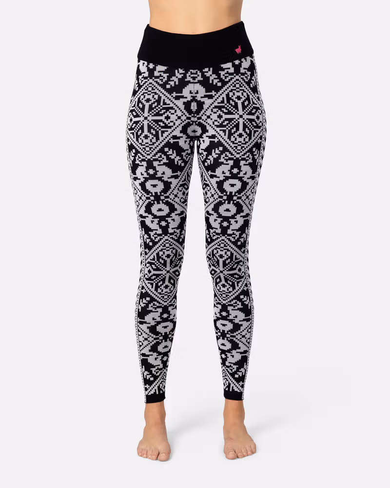Side view of a woman in black Kari Traa Saga Base Layer Pants with a white Nordic pattern.